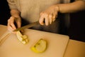 A woman slices through a crisp apple, revealing its juicy flesh. This image highlights themes of domesticity, nourishment, and Royalty Free Stock Photo