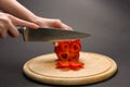 Woman slices red pepper on chopping board Royalty Free Stock Photo