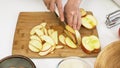 Woman slicing apples. Close up on a wooden cutting board Royalty Free Stock Photo