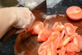 Woman slicing raw tomato