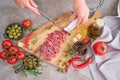 Woman slicing Spanish sausage fuet salami with knife on a domestic kitchen