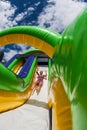 Woman Slides Down Obstacle Course Inflatable Slide At Fitness Event