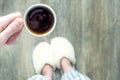 woman in slippers holds a cup of coffee in her hands. Morning concept