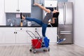 Woman Slipping While Mopping Floor In Kitchen