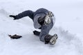 A woman slips on a snow-covered sidewalk