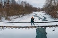 Woman on the small bridge over the frozen river in winter Royalty Free Stock Photo