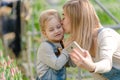 A woman with a small daughter make a selfie in a greenhouse with flowers.