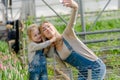 A woman with a small daughter make a selfie in a greenhouse with flowers.