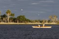 Woman and small dog kayaking in the Gulf of Mexico with birds flying overhead