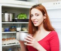 Woman with small pan near opened refrigerator Royalty Free Stock Photo