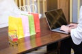 Woman and Small shopping cart with Laptop for Internet online shopping concept Royalty Free Stock Photo