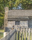 Woman with smart phone in front of a 9th century cabin