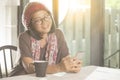 Woman and smarthphone in hand sitting in coffee shop against eur Royalty Free Stock Photo