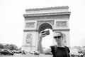 Woman with smartphone at arch monument in paris, france. Woman make selfie with phone at arc de triomphe. Vacation and Royalty Free Stock Photo