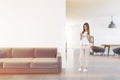White living room interior, sofa, smartphone woman Royalty Free Stock Photo