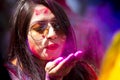 A woman smeared with colored powder, takes part in celebrations of the Dol Utsav Festival