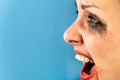 Woman with smeared makeup screams on a blue background Royalty Free Stock Photo