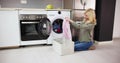 Woman Smelling Clean Clothes Near The Electronic Washer Royalty Free Stock Photo