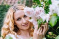 Woman smelling and enjoying beautiful roses flowers beautiful sunny spring day. Smiling young woman posing with blossom Royalty Free Stock Photo