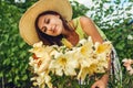 Woman smelling flowers in garden. Gardener taking care of yellow lilies. Girl growing plants. Summer outdoor hobby Royalty Free Stock Photo