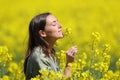 Woman smelling flowers in a yellow field Royalty Free Stock Photo