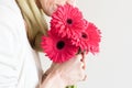 Woman smelling gerberas (cropped)