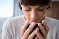 Woman smelling her cup of coffee with her eyes closed Royalty Free Stock Photo