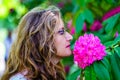 Woman smelling a large flower of intense colors in spring. Royalty Free Stock Photo