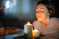 Woman smelling a lighted candle in the night