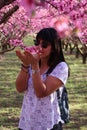 Woman smells the pretty pink peach blossoms Royalty Free Stock Photo