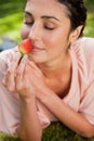 Woman smells an strawberry while lying in grass Royalty Free Stock Photo
