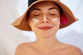 Woman smile applying sun cream on face. Skincare. Body Sun protection. sunscreen.