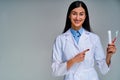 Happy female doctor with a phonendoscope in a white medical coat point on toothbrush and toothpaste. Dental concept