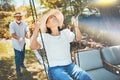 Woman, smile and fun on swing in retirement, playful and joy in summer vacation for quality time. Happy elderly people Royalty Free Stock Photo