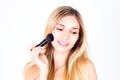 Woman with smile with teeth apply blush on face with large brush