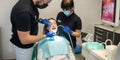 woman smiles during dental treatment at the dentist by a man and his female assistant. Royalty Free Stock Photo