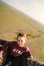 Woman smiles while on a hot air balloon safari ride in the Masai Mara Reserve in Kenya, Africa. Artistic angle of photo