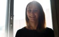 Woman smiling and backlit in the window.