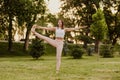 Woman is smiling and balancing on one foot. Beautiful young woman practicing utthita hasta padangusthasana yoga asana in