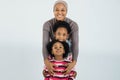 Woman smiling on camera while embracing her cute daughters Royalty Free Stock Photo