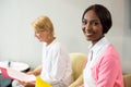 Woman smiling at camera while her colleague reading document Royalty Free Stock Photo