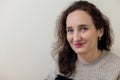 Woman smiling in a closeup portrait with a neutral background, A closeup portrait of a smiling woman with a neutral Royalty Free Stock Photo