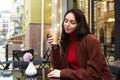 Woman smiling with a cup of coffee outside, drinking coffee on the terrace in a cafe Royalty Free Stock Photo