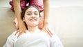 Woman is smiling while getting thai massaged on shoulder