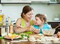 Woman with a smiling girl dumplings fish cooking together at ho