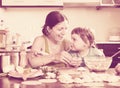 Woman with a smiling girl dumplings fish cooking together at ho Royalty Free Stock Photo