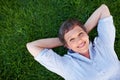 Woman smiling in grass. Top view of beautiful mature woman smiling while lying on grass. Royalty Free Stock Photo