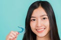 Woman smiling holding silicone orthodontic retainers for teeth