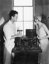 Woman smiling at a man next to an editing machine Royalty Free Stock Photo