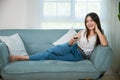 woman smiling sitting relax watch TV holding remote control Royalty Free Stock Photo